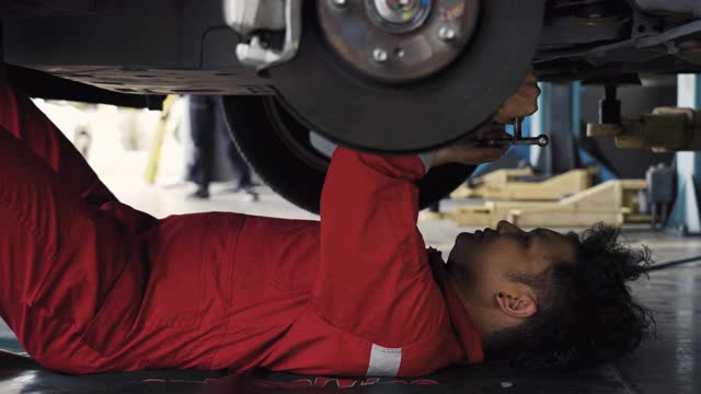 汽车修理工在汽车修理厂修理发动机。视频下载