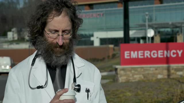 焦急的男医生站在医院急诊室门口视频下载