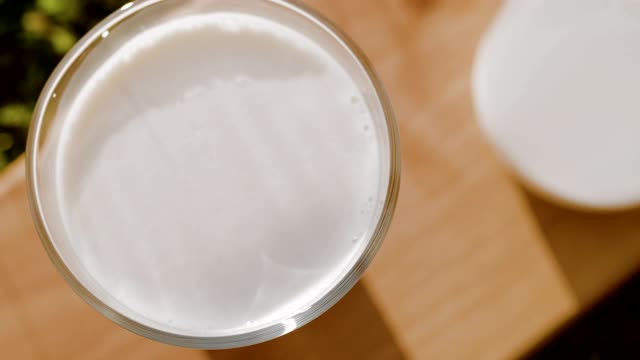 牛奶滴掉进玻璃杯的时间扭曲镜头视频下载