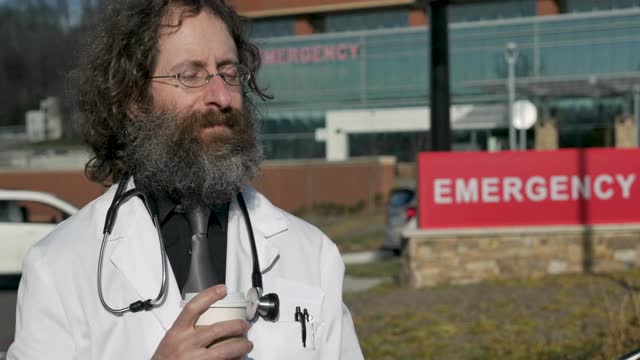 疲惫不堪的男医生在急救医院外面喝咖啡视频下载
