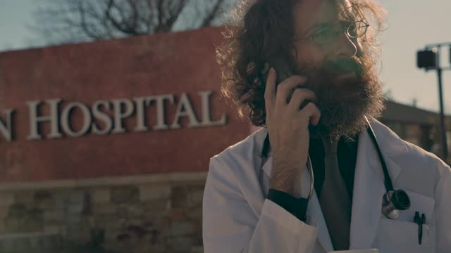 男医生站在医院门口用手机打电话视频下载