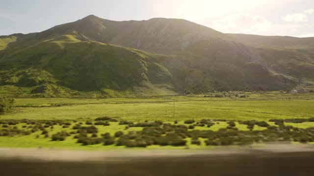 在英国威尔士的斯诺登尼亚国家公园开车时看到的风景优美的山和田野视频素材