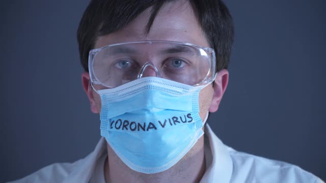 实验室的医生戴着医用口罩，上面写着冠状病毒，实验室的技术人员双手交叉示意停止。医护人员用药、寻找疫苗和治疗新冠肺炎19视频下载