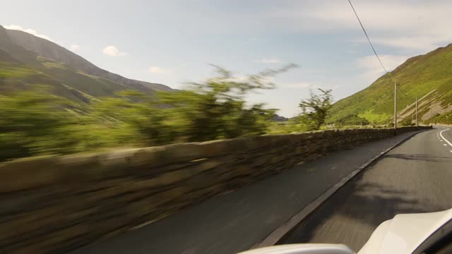 开车穿过斯诺登尼亚国家公园郁郁葱葱的乡村山谷和山脉，在公路上超速行驶时，在汽车视野之外徘徊视频素材