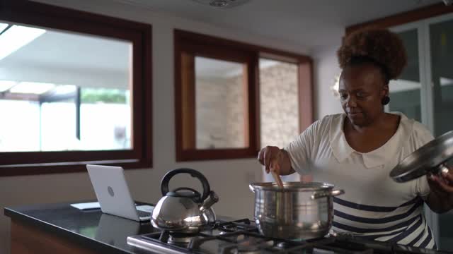 高级妇女在家做饭视频素材