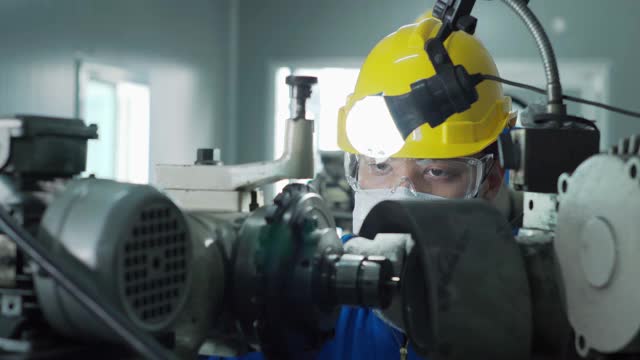 在制造工厂使用机械的团队工程师。视频素材