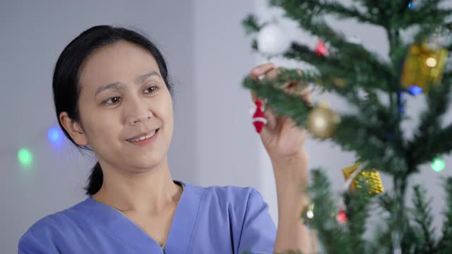 亚洲妇女在家里装饰圣诞树视频素材