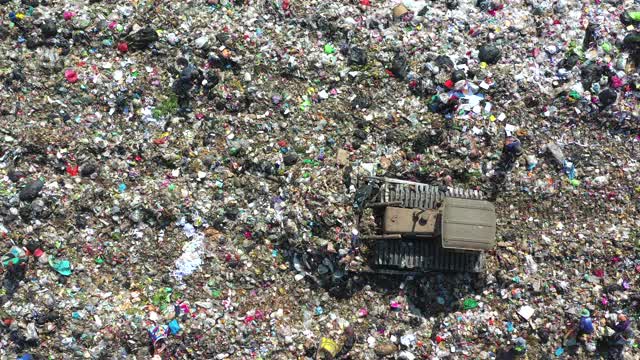 垃圾填埋场用垃圾车处理垃圾，鸟瞰图视频素材