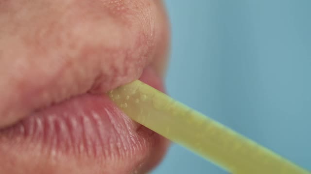 一个男人的嘴唇用吸管，喝着饮料，特写视频下载