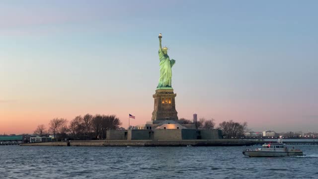 日落时分，自由女神像在小船的后面视频素材