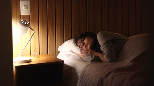 女人躺在床上无法入睡，人在晚上辗转反侧压力山大视频素材