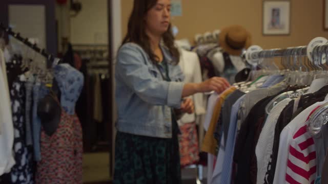 年轻女性在旧货店买衣服视频下载