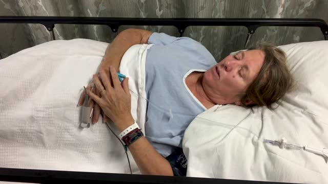 一名妇女躺在医院病床上，腹部疼痛视频素材