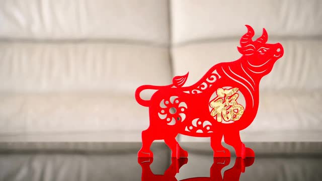 潘观站立的牛吉祥物在沙发前作为象征的中国新年的牛，中国意味着好运视频素材