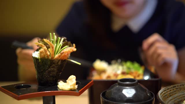 年轻的亚洲女人正在吃日本餐视频素材