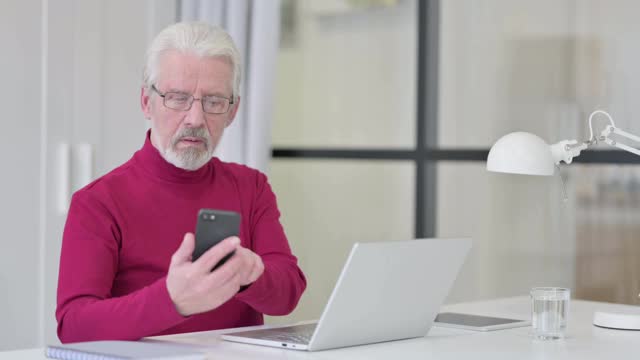 在工作中使用智能手机的老人视频素材