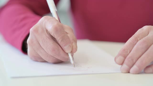 老人在纸上写字的手视频素材