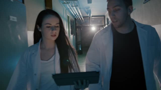 两个急诊医生在医院走廊里用着平板电脑视频下载