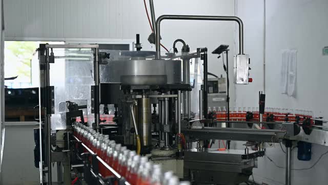 灌装厂红汁生产线上的自动产品贴标机械视频素材