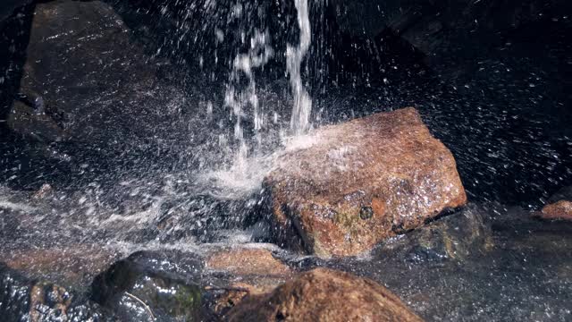 山川在巨石中流淌。水滴从石头上溅起视频素材