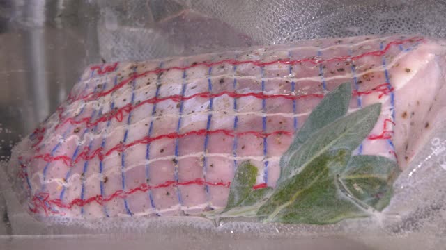 将猪里脊或里脊肉片密封于真空袋内，浸于水浴中进行真空烹调视频素材