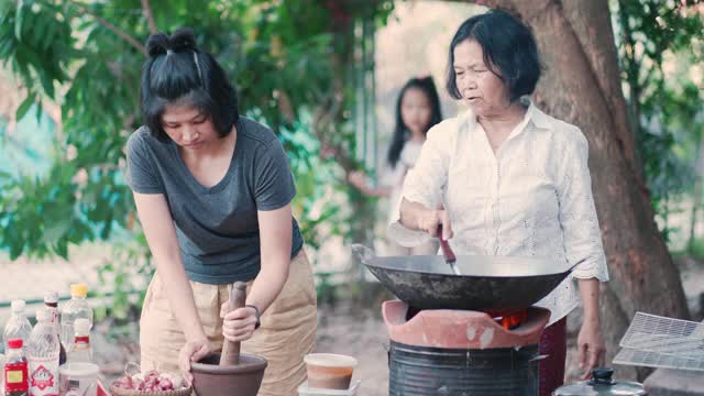 亚洲妈妈和女儿在家里烹饪传统食物视频素材
