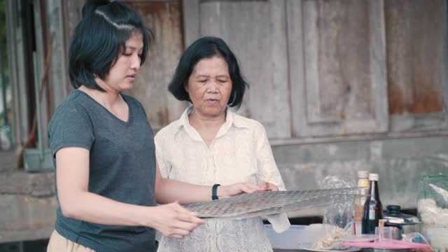 Asian Mom and Daughter cooking traditional food at home亚洲妈妈和女儿在家里烹饪传统食物视频素材