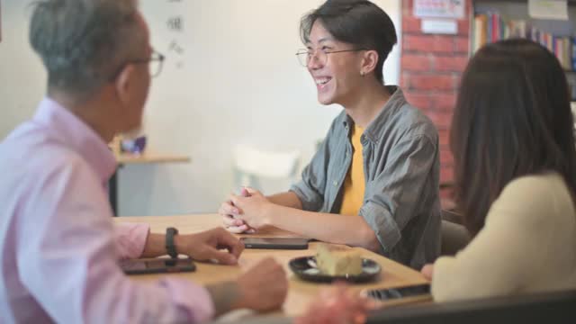 亚洲女性与唐氏综合症女服务员服务的顾客在咖啡馆视频下载