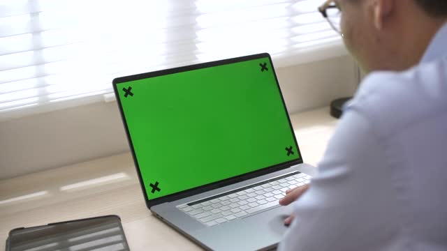 用绿屏笔记本电脑的人视频素材