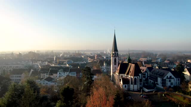在一个阳光明媚的早晨，无人机拍摄的一个德国小镇上有著名的教堂视频下载