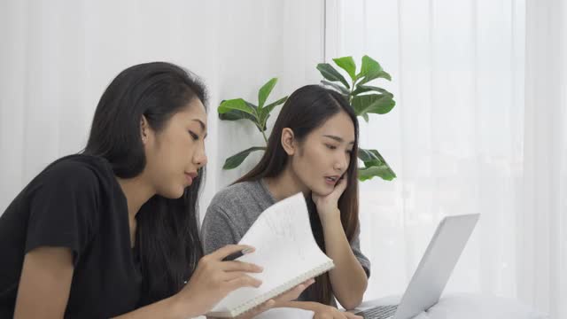 两个女孩在学习，通过笔记本电脑打视频电话。视频素材