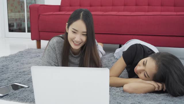 两个女孩在学习，通过笔记本电脑打视频电话。视频素材