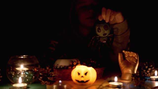 万圣节前夕，神秘男孩在暗室里与蜡烛旁的蜘蛛玩耍视频下载