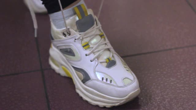 年轻女子把鞋带系在白色运动鞋上视频下载