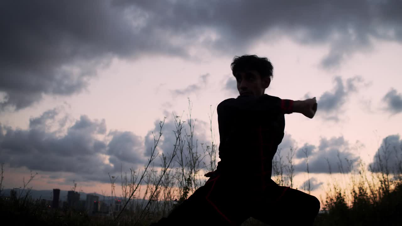 夕阳下一个男人练习武术的剪影。功夫视频下载