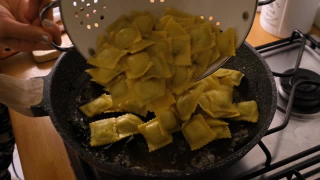 慢动作扔和煮饺子通心粉在煎锅与黄油和鼠尾草视频素材