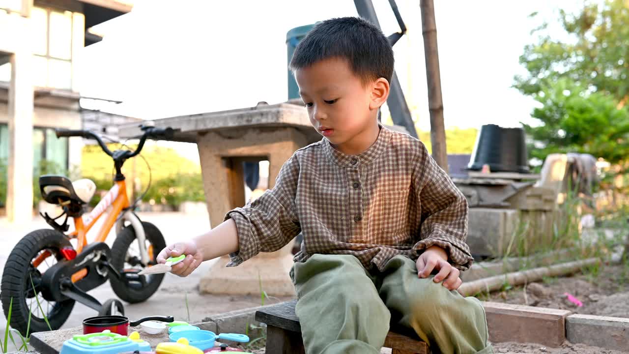 亚洲男孩正在用玩具在沙盒里玩沙视频下载