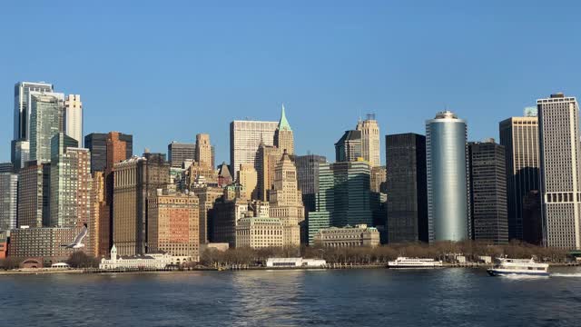一个阳光明媚的日子，曼哈顿市中心炮台公园，繁忙的港口，渡船经过视频素材
