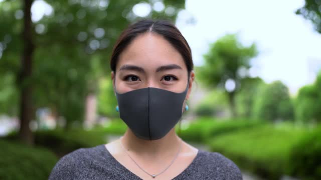 亚洲妇女摘下面具的肖像。结束冠状病毒概念的视频。视频素材