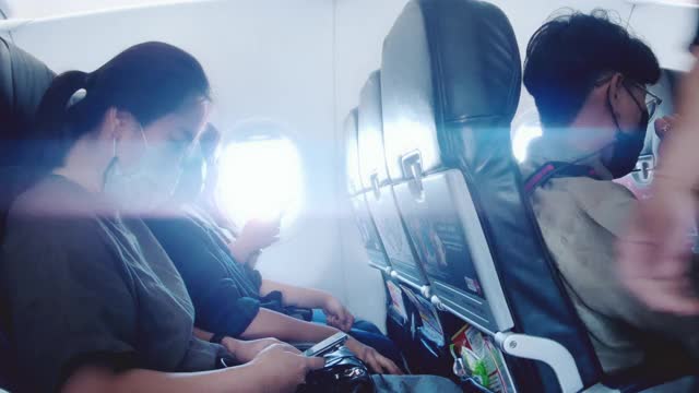 流感季节:戴口罩坐在飞机座位上视频素材