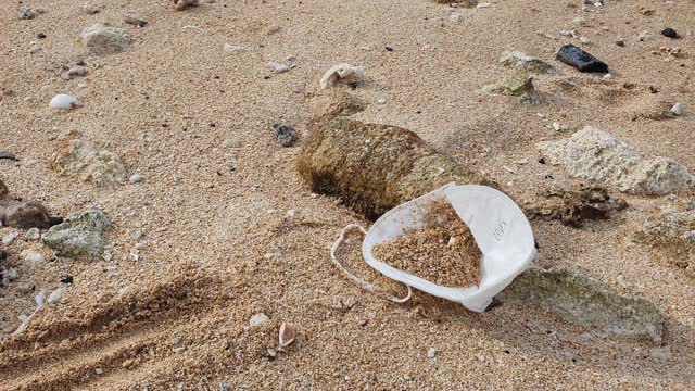 在新冠肺炎大流行期间，被丢弃在印度尼西亚巴厘岛努沙杜瓦海滩上的冠状病毒口罩视频素材