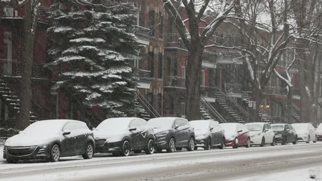 蒙特利尔高原住宅区一排房子和停放的汽车在暴风雪期间视频素材