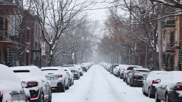 蒙特利尔高原住宅区街景与停在暴风雪期间的汽车视频素材