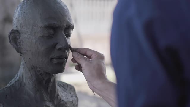亚洲人雕塑家创造一个泥塑。视频下载