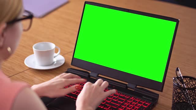 电子教育，女性在笔记本电脑上观看绿色屏幕的色度关键技术，视频素材