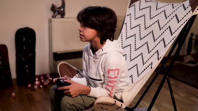 2019冠状病毒病大流行期间，男孩在家玩电子游戏视频下载