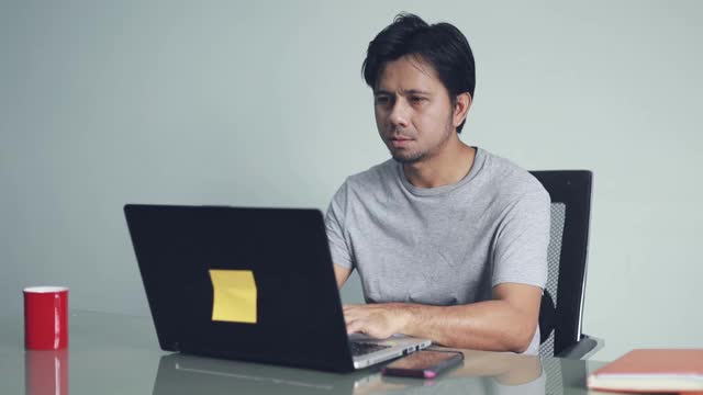年轻的亚洲男人工作压力大，办公室综合症视频素材
