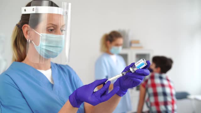 医生戴医用手套和口罩，手持新型冠状病毒疫苗，预防和治疗新型冠状病毒感染视频素材