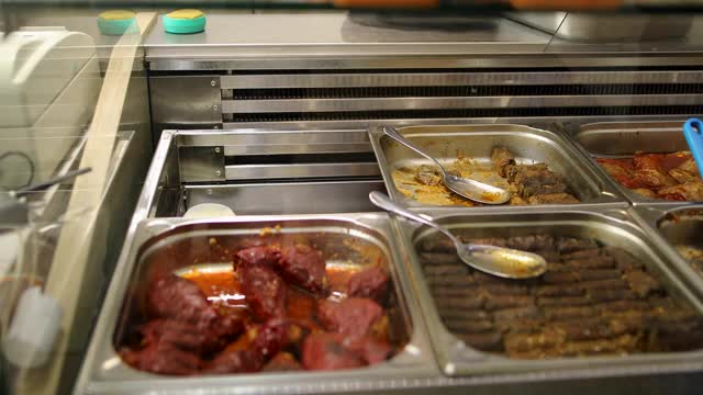 在自助餐中各种各样的熟食在钢制托盘和服务用具。填料辣椒和青米肉卷视频下载