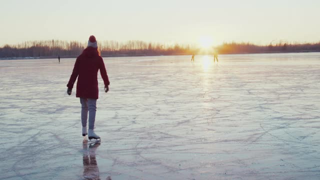 女人在结冰的湖面上滑冰视频素材
